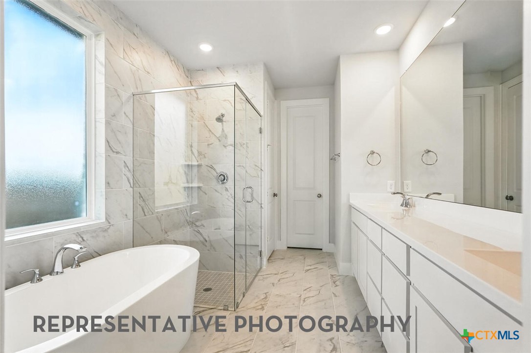 8905 Turaco Trail Austin, TX 78744 - Photo 12 of 27 a spacious bathroom with a shower sink and a mirror