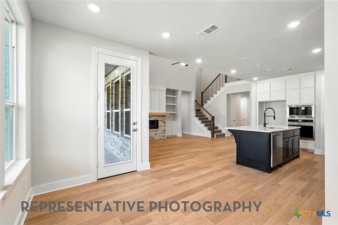 8905 Turaco Trail Austin, TX 78744 - Photo 17 of 27 a view of kitchen with furniture and wooden floor