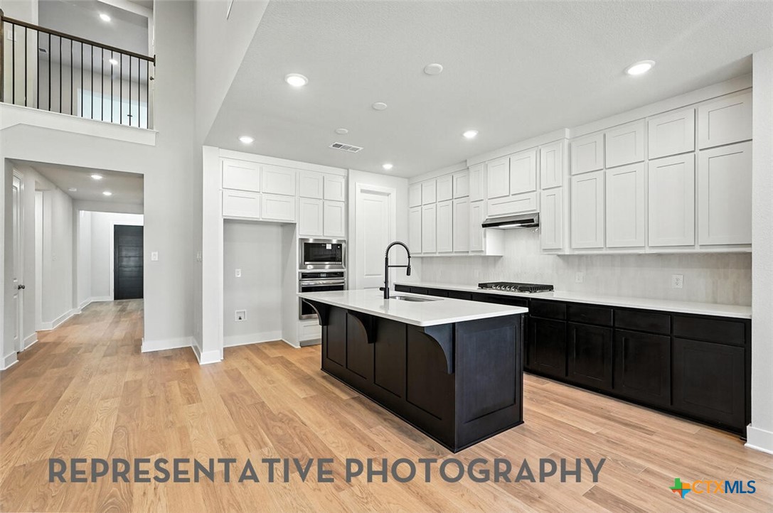 8905 Turaco Trail Austin, TX 78744 - Photo 2 of 27 a large kitchen with stainless steel appliances granite countertop a stove a sink and a refrigerator
