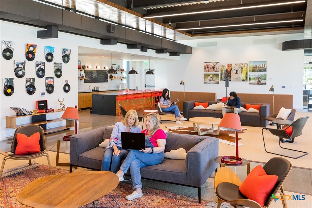 8905 Turaco Trail Austin, TX 78744 - Photo 26 of 27 a living room with furniture a rug and a chandelier