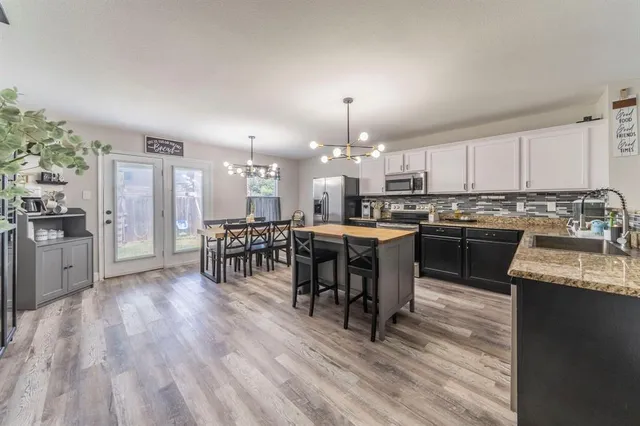 a kitchen with stainless steel appliances granite countertop a sink stove and microwave