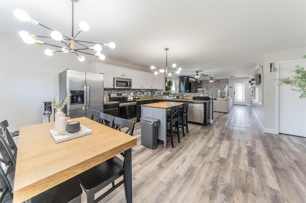 133 Adams Avenue Venus, TX 76084 - Photo 10 of 40 a kitchen with a dining table chairs stainless steel appliances and cabinets