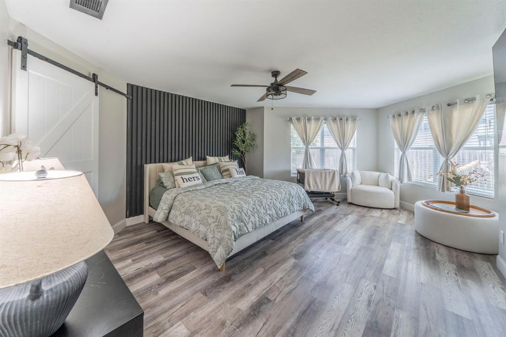 133 Adams Avenue Venus, TX 76084 - Photo 11 of 40 a bedroom with a large bed couch and windows