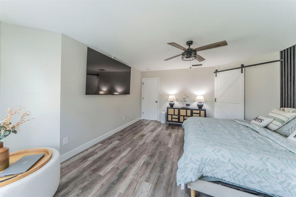 133 Adams Avenue Venus, TX 76084 - Photo 12 of 40 a spacious bedroom with a bed and a flat screen tv