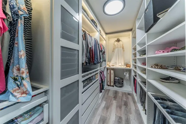 a spacious bedroom with a bed and a flat screen tv