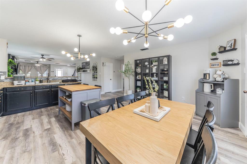 133 Adams Avenue Venus, TX 76084 - Photo 39 of 40 a kitchen with kitchen island a stove a sink a refrigerator dining table and chairs