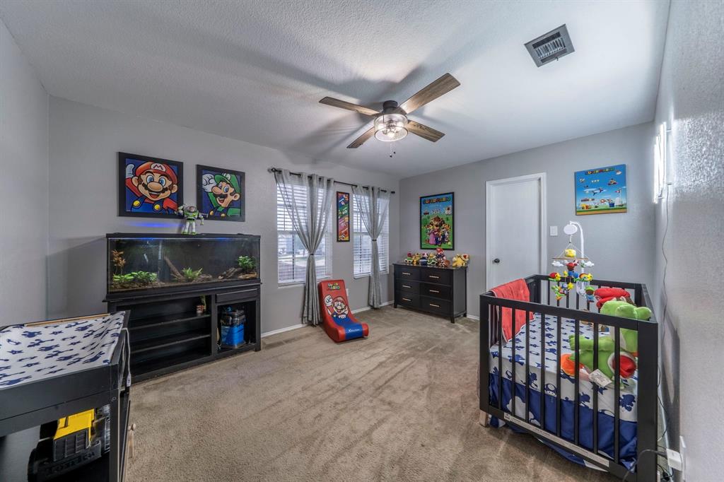 133 Adams Avenue Venus, TX 76084 - Photo 29 of 40 a bedroom with furniture a baby crib and a chandelier