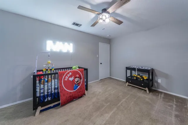 a bedroom with furniture a baby crib and a chandelier