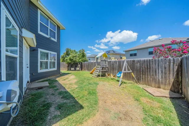 a front view of a house with a yard and potted plants