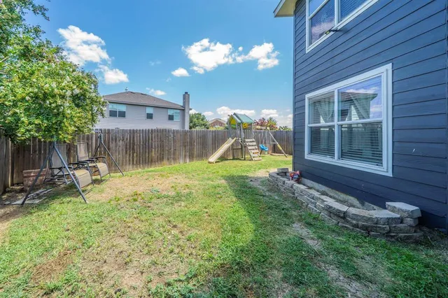 a view of an house with backyard and a slide