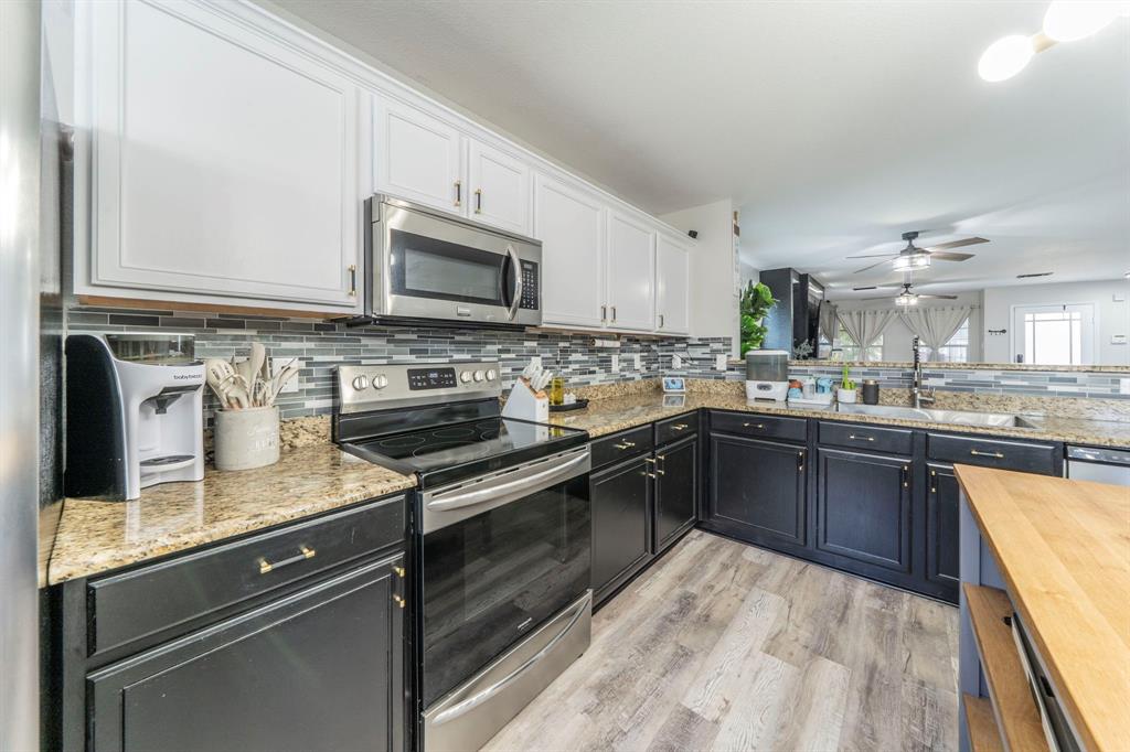 133 Adams Avenue Venus, TX 76084 - Photo 7 of 40 a kitchen with stainless steel appliances granite countertop a sink stove and microwave