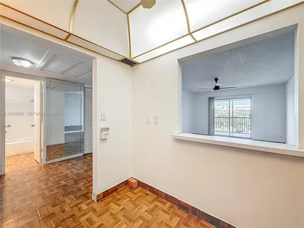 a view of a hallway with wooden floor and a window