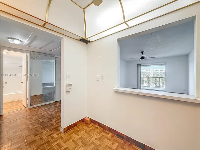 a view of a hallway with wooden floor and a window