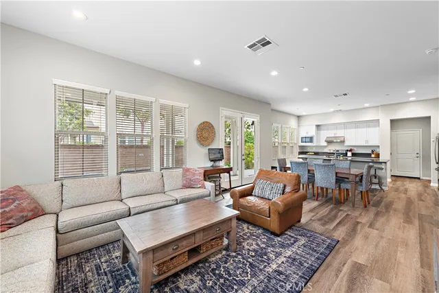 a kitchen with stainless steel appliances granite countertop a refrigerator a stove top oven a sink dishwasher and white cabinets with wooden floor