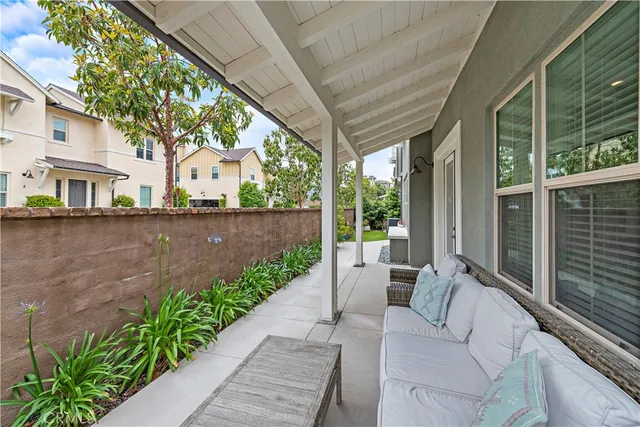 a view of a patio with couches table and chairs and potted plants