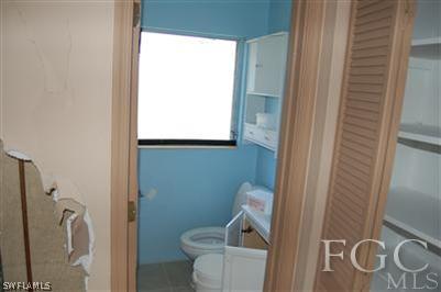 14 Arkansas Road Lehigh Acres, FL 33936 - Photo 5 of 7 a white toilet sitting next to a bathroom sink