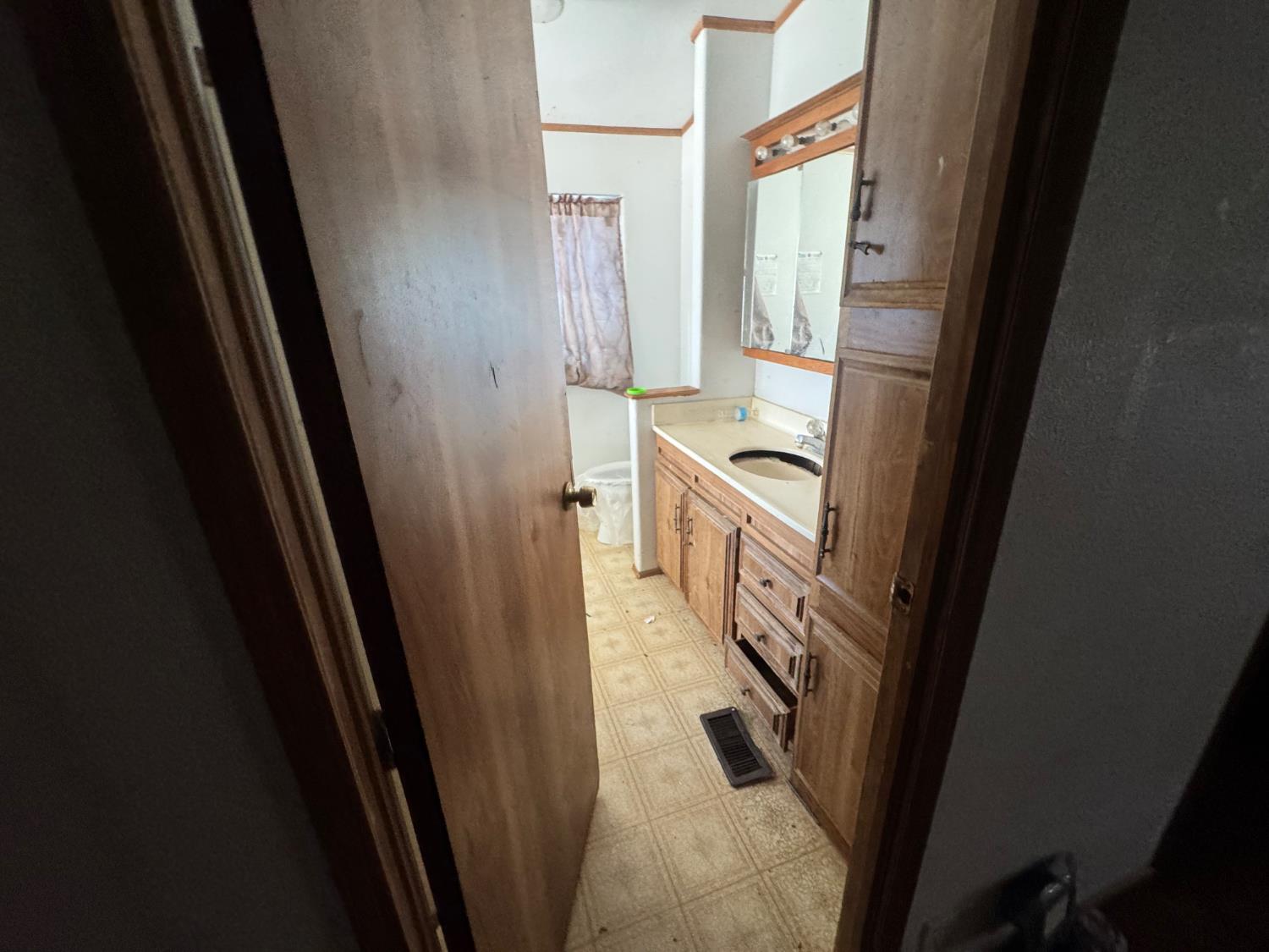 601 South Phillips Street Hanford, CA 93230 - Photo 9 of 18 a bathroom with a sink a mirror a washer and dryer
