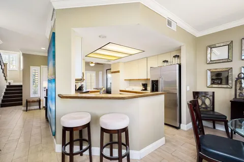 a kitchen with stainless steel appliances a dining table chairs and chandelier