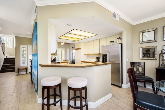 a kitchen with stainless steel appliances a dining table chairs and chandelier