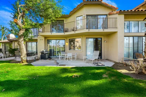 a front view of a house with swimming pool and chairs