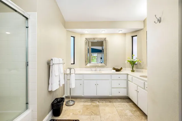 a spacious bathroom with a tub sink and mirror