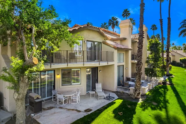 a view of a chair and table in backyard of the house