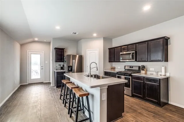 a kitchen with stainless steel appliances a sink stove and refrigerator