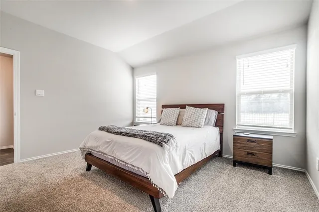 a bed sitting in a bedroom next to a window