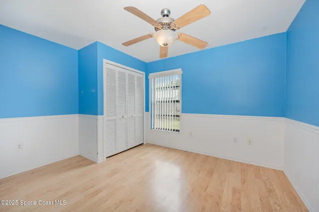 an empty room with a window and a ceiling fan