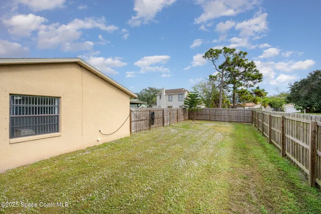 a view of backyard of house and entertaining space