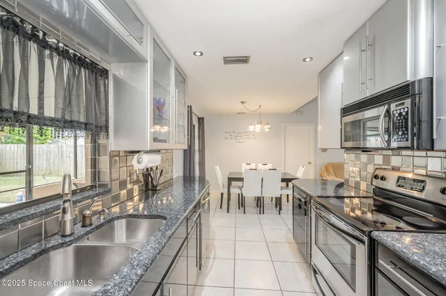 a kitchen with stainless steel appliances granite countertop a sink a stove and a microwave