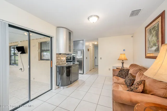 a living room with furniture and a refrigerator