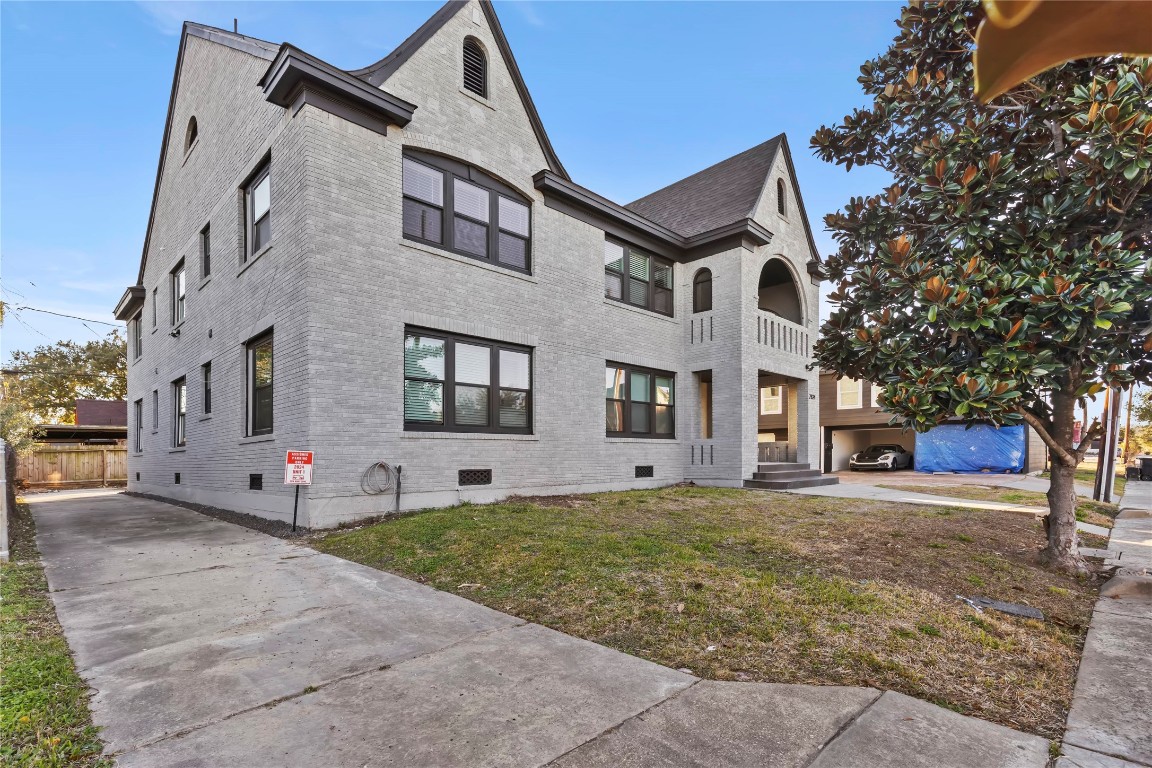 a view of a white house with a yard and large tree