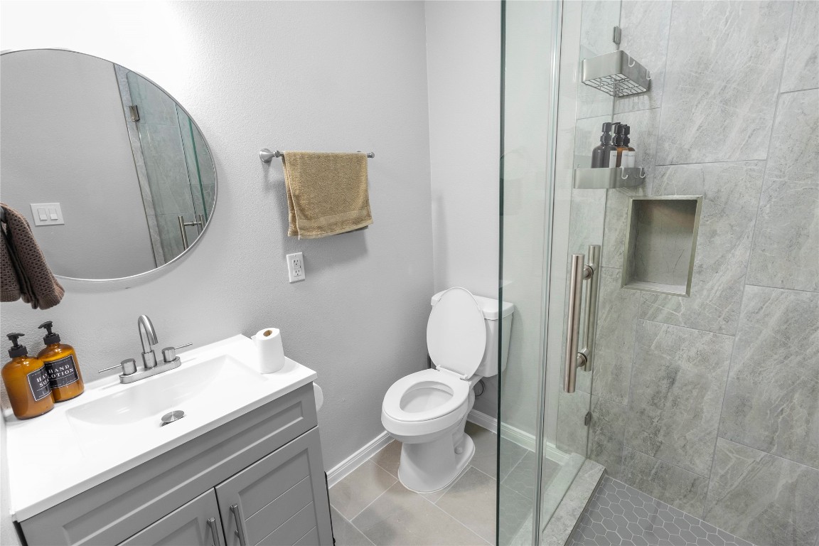 2824 Blodgett Street, Unit 2 Houston, TX 77004 - Photo 24 of 25 a bathroom with a sink a toilet and shower curtain