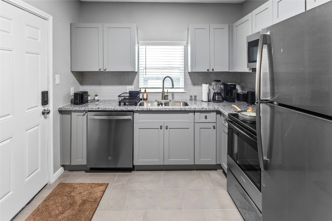 2824 Blodgett Street, Unit 2 Houston, TX 77004 - Photo 9 of 25 a kitchen with a sink stove and refrigerator
