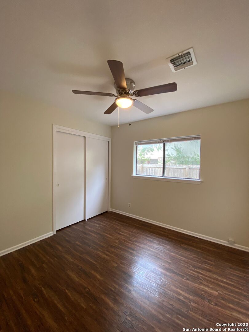 7214 Rimwood Street Live Oak, TX 78233 - Photo 16 of 24 a view of an empty room with wooden floor and a window