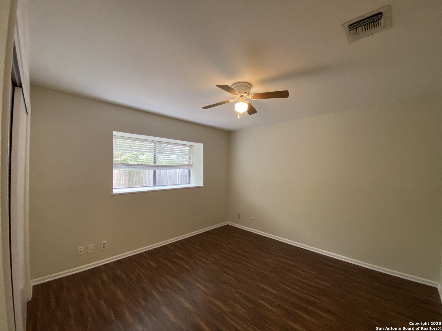 7214 Rimwood Street Live Oak, TX 78233 - Photo 17 of 24 a view of an empty room with a window and wooden floor