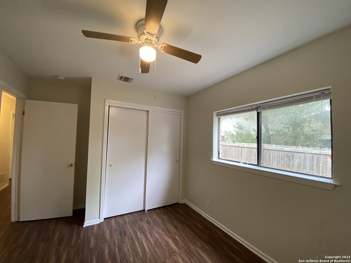7214 Rimwood Street Live Oak, TX 78233 - Photo 18 of 24 an empty room with wooden floor fan and windows