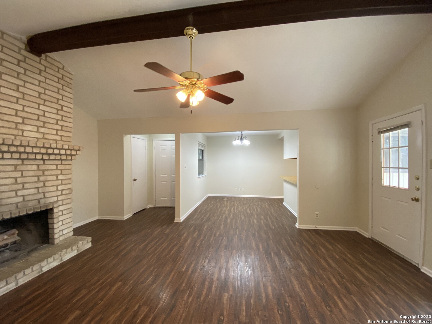7214 Rimwood Street Live Oak, TX 78233 - Photo 5 of 24 an empty room with wooden floor a chandelier fan and windows
