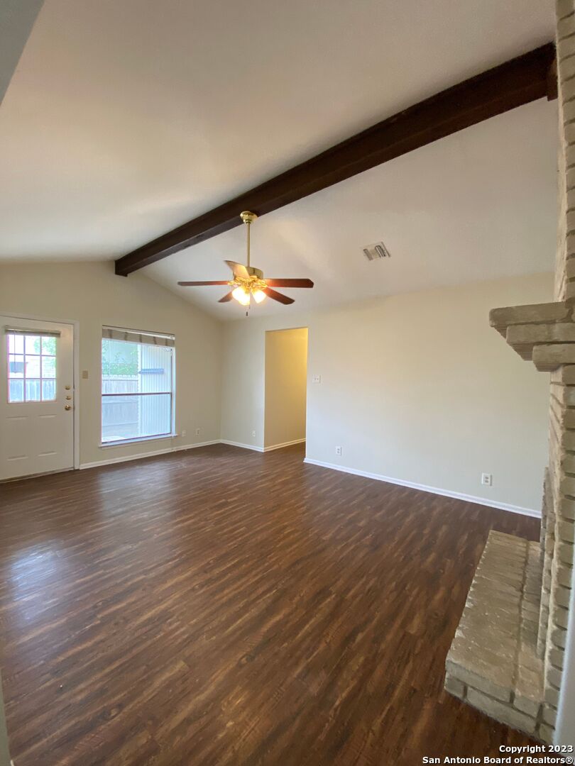 7214 Rimwood Street Live Oak, TX 78233 - Photo 6 of 24 an empty room with wooden floor chandelier fan and windows
