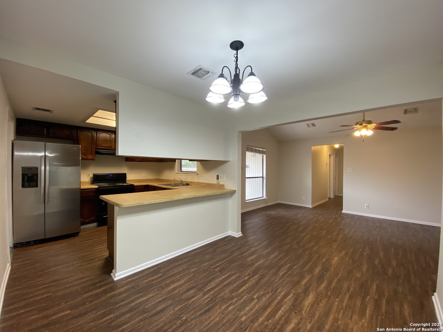 7214 Rimwood Street Live Oak, TX 78233 - Photo 7 of 24 a view of a kitchen counter space wooden floor and a ceiling fan