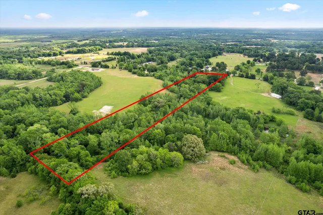 an aerial view of a city with lots of residential buildings ocean and mountain view in back