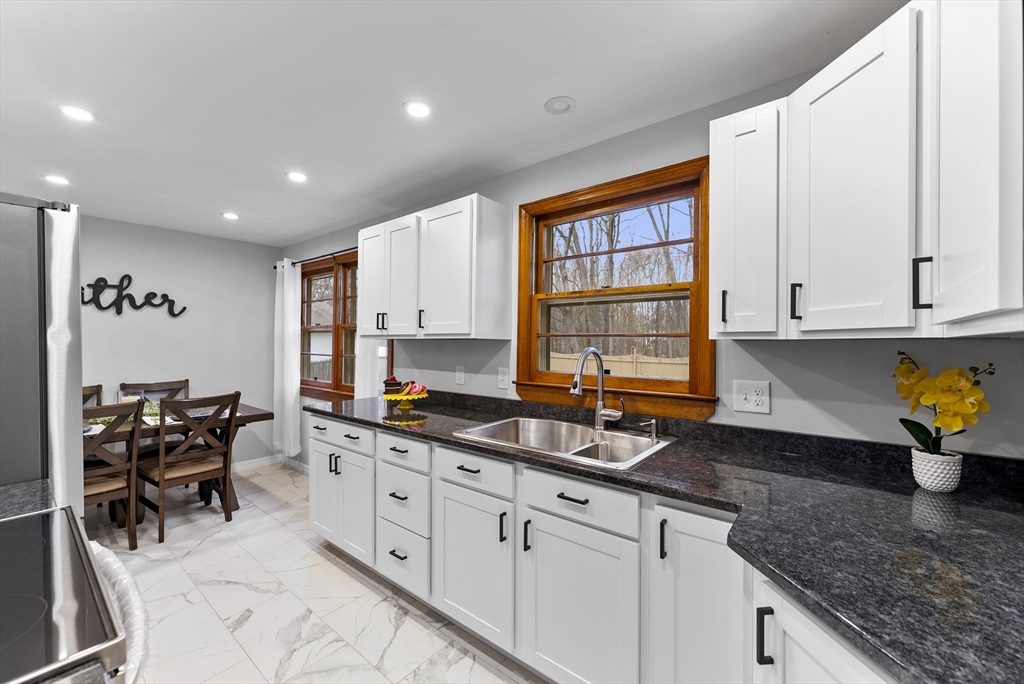 73 Herrman Street West Springfield, MA 01089 - Photo 5 of 38 a kitchen with granite countertop a stove a sink a counter space and cabinets