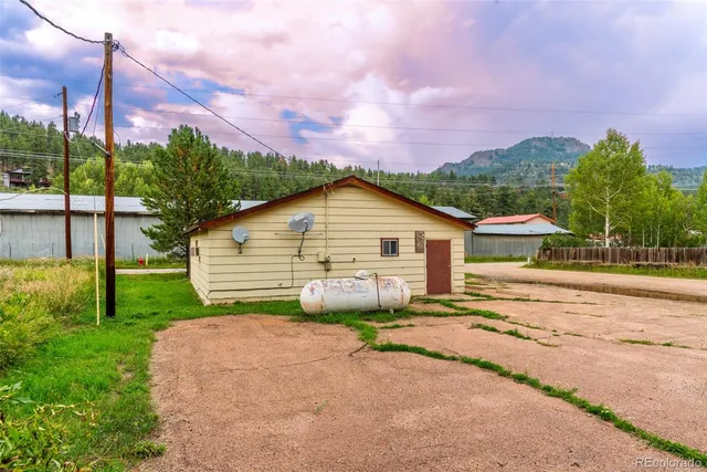 a view of a house with a yard and potted plants
