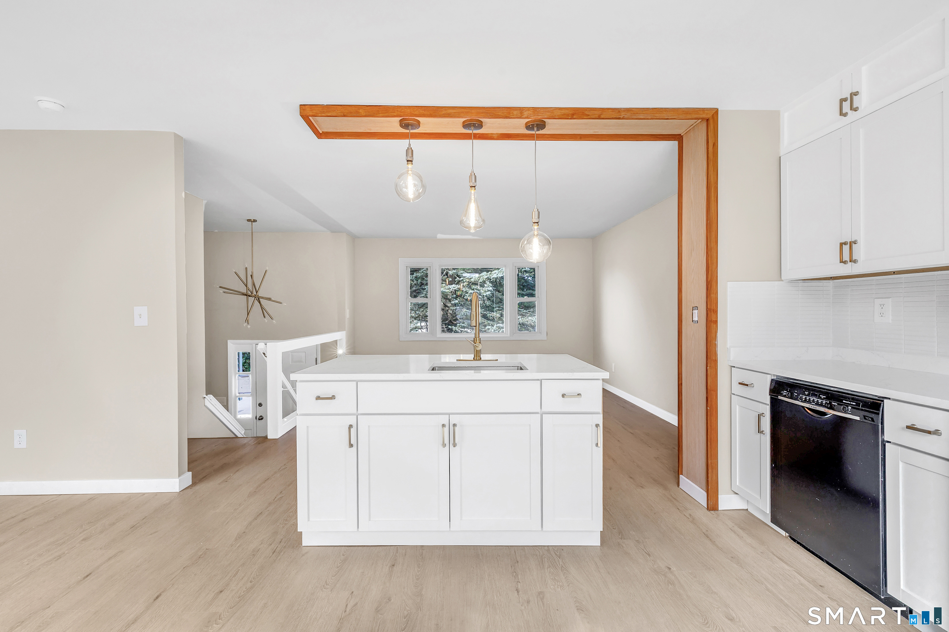 77 Meadow Lark Road Naugatuck, CT 06770 - Photo 11 of 40 Kitchen - White cabinetry, white quartz counter tops with matching custom built island w/ deep sink & electrical outlets, New Sliding Door that leads to rear deck, Freshly painted, installed luxury vinyl floor on both floors,