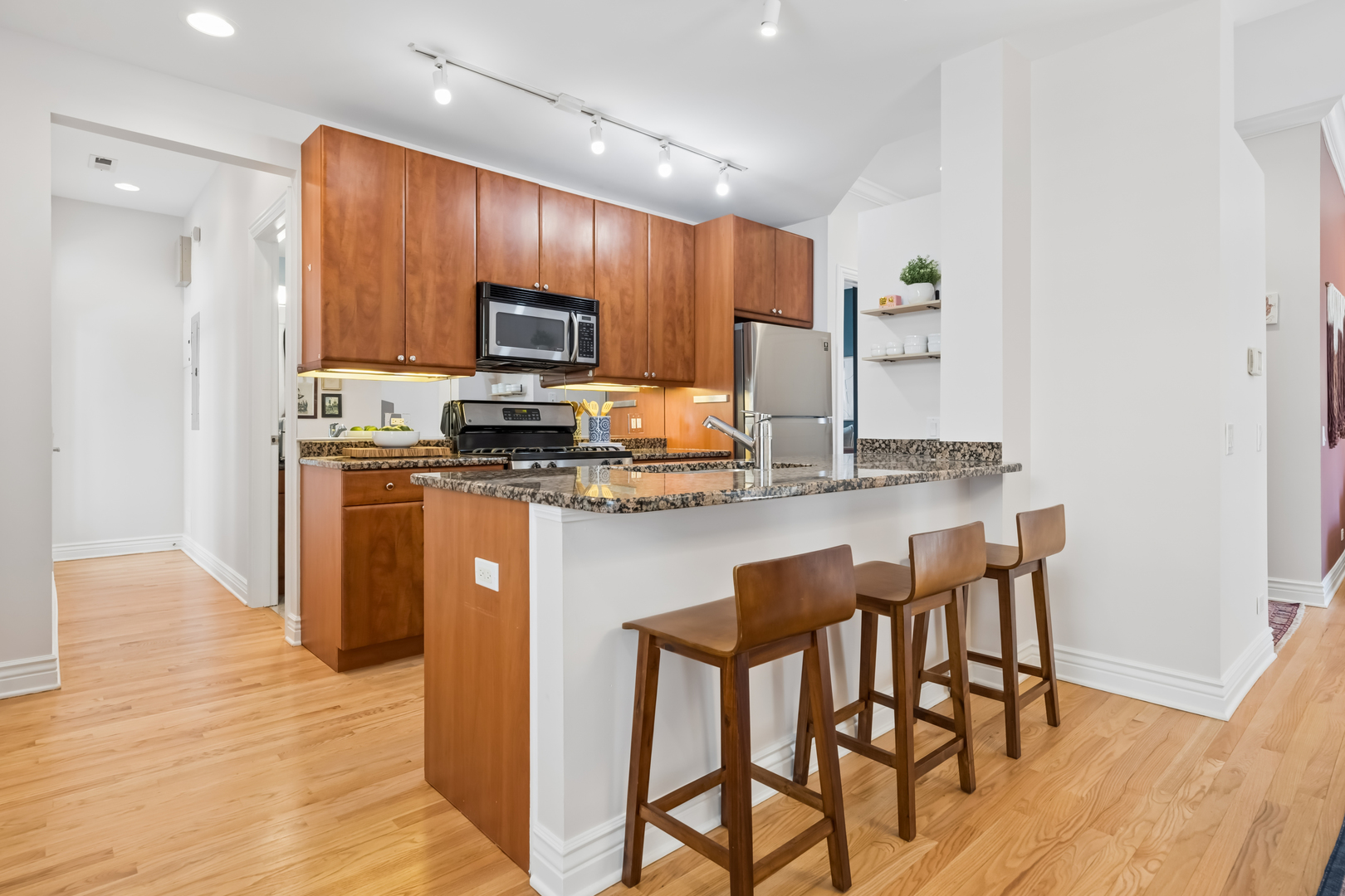 2547 North Clark Street, Unit 2N Chicago, IL 60614 - Photo 10 of 25 a kitchen with granite countertop a stove top oven a sink a dining table and chairs