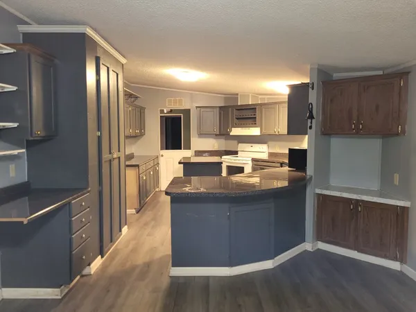 a kitchen with kitchen island stainless steel appliances a sink stove refrigerator and cabinets