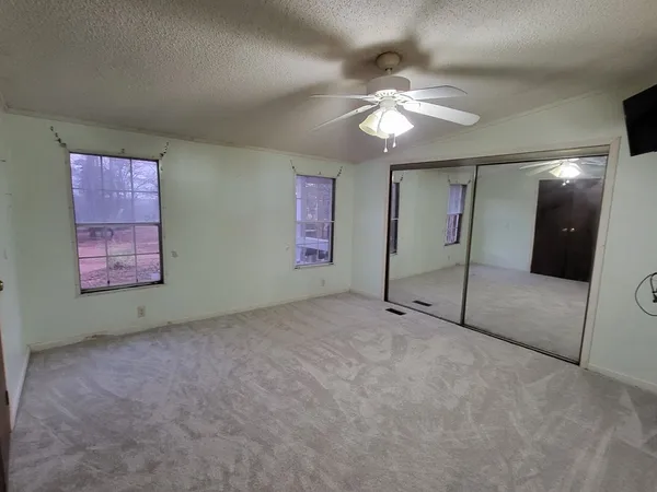 a view of an empty room with a chandelier fan