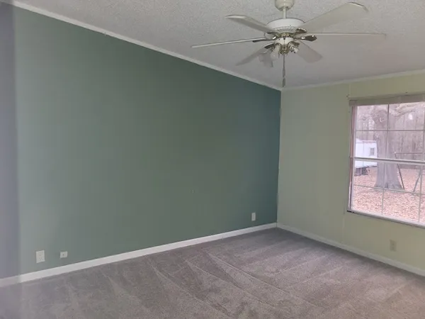 an empty room with a window and a fan