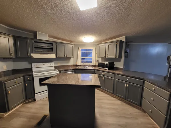 a kitchen with stainless steel appliances granite countertop a sink stove microwave and cabinets